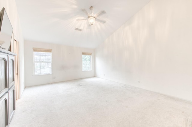 carpeted empty room featuring ceiling fan and lofted ceiling