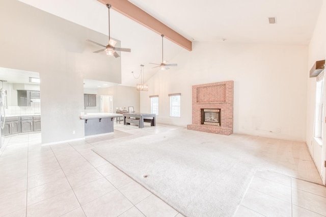 unfurnished living room featuring a fireplace, ceiling fan, light tile patterned floors, high vaulted ceiling, and beamed ceiling