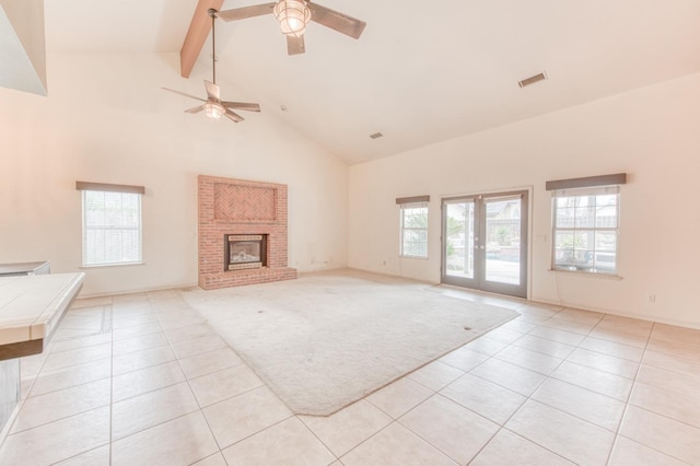 unfurnished living room with a fireplace, beam ceiling, a wealth of natural light, and ceiling fan