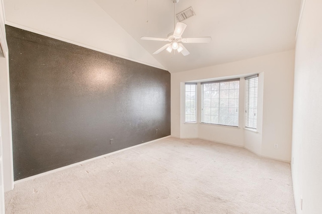 spare room with ceiling fan, lofted ceiling, and light carpet