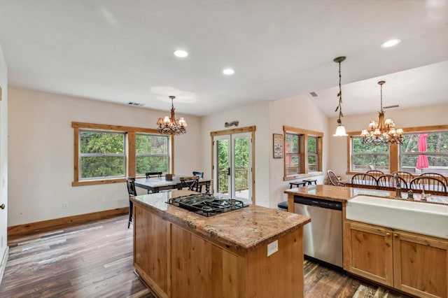 kitchen with a center island, sink, stainless steel dishwasher, dark hardwood / wood-style flooring, and a chandelier