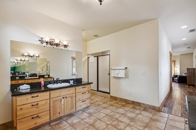 bathroom with tile patterned flooring, vanity, and walk in shower