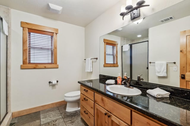 bathroom with vanity, toilet, and a shower with door