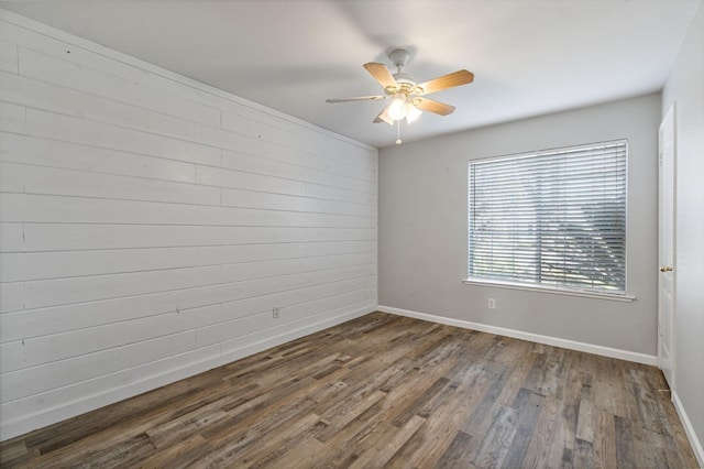 empty room with a ceiling fan, baseboards, and wood finished floors