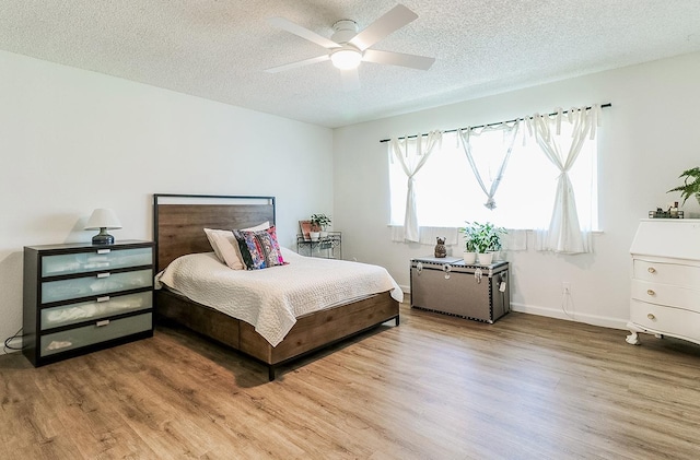 bedroom featuring hardwood / wood-style flooring, ceiling fan, and a textured ceiling