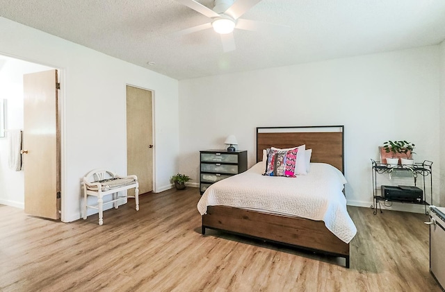 bedroom with ceiling fan, a textured ceiling, and light hardwood / wood-style flooring