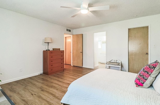 bedroom featuring connected bathroom, ceiling fan, a textured ceiling, and hardwood / wood-style flooring