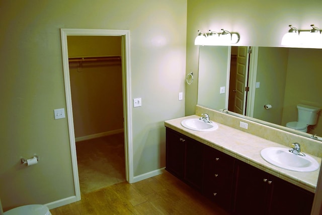 bathroom with hardwood / wood-style floors, vanity, and toilet