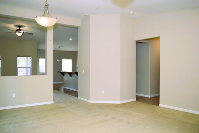 carpeted spare room with ceiling fan