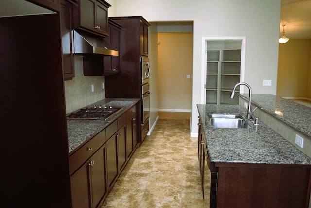 kitchen featuring backsplash, stainless steel appliances, dark stone counters, and sink