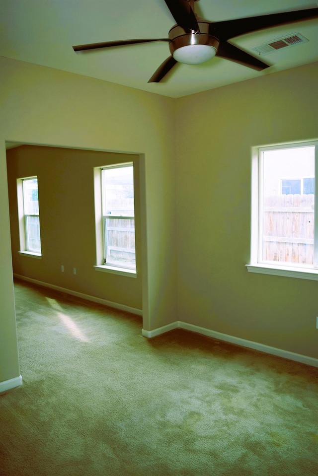 spare room with light colored carpet and ceiling fan