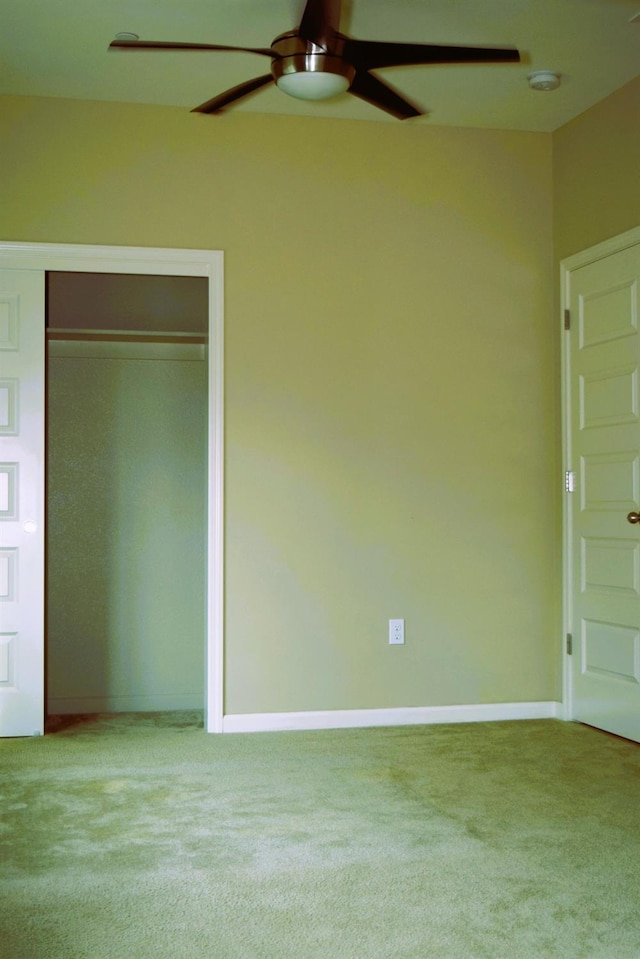 unfurnished bedroom with a closet, light colored carpet, and ceiling fan