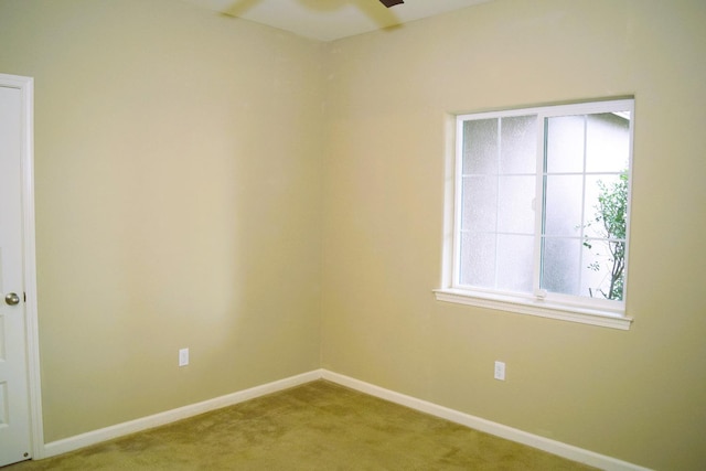 carpeted spare room with ceiling fan