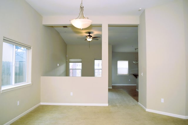 spare room featuring plenty of natural light, ceiling fan, and light carpet