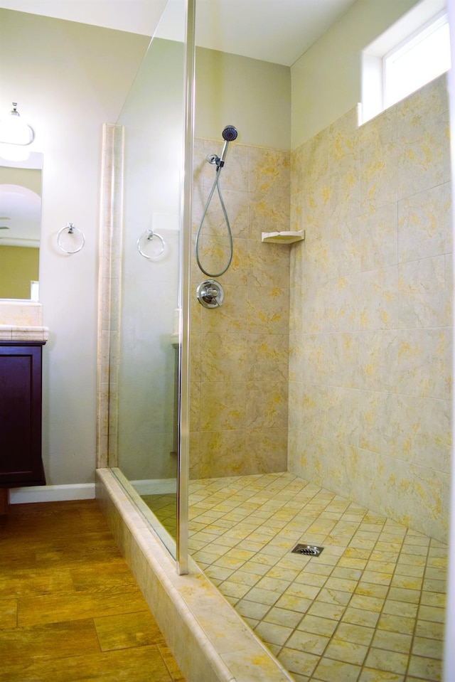 bathroom featuring hardwood / wood-style floors, vanity, and tiled shower