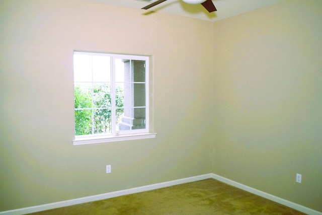 carpeted spare room featuring ceiling fan