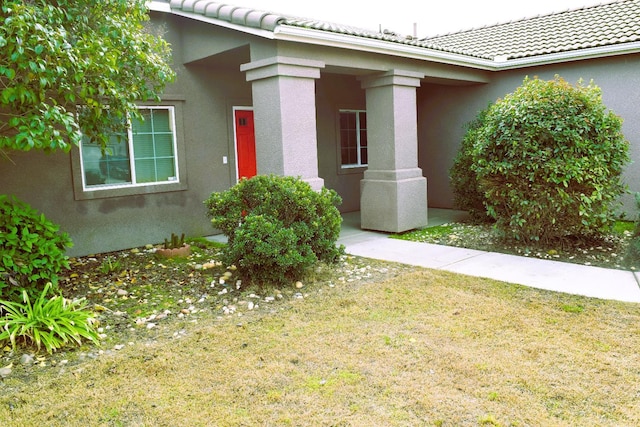 entrance to property featuring a lawn