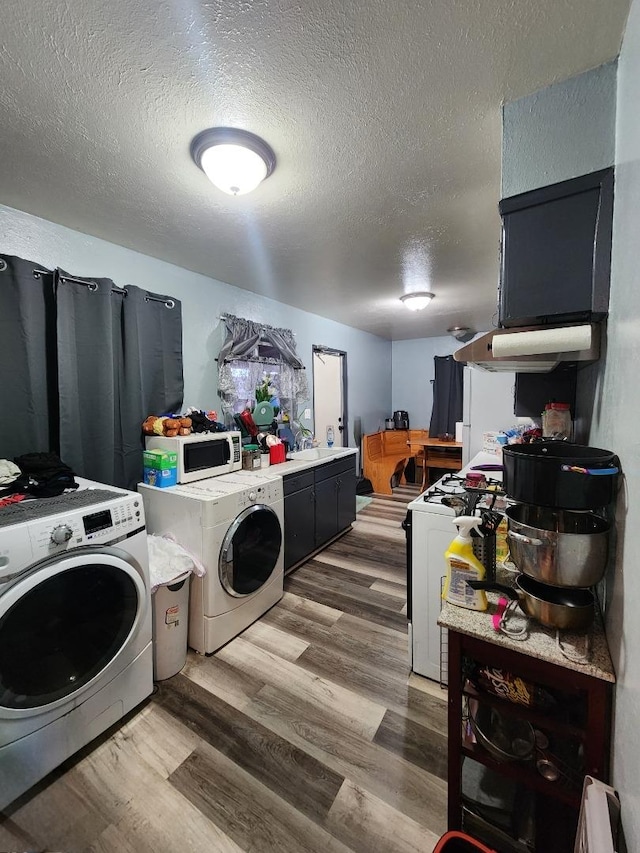 washroom featuring hardwood / wood-style flooring, a textured ceiling, and independent washer and dryer