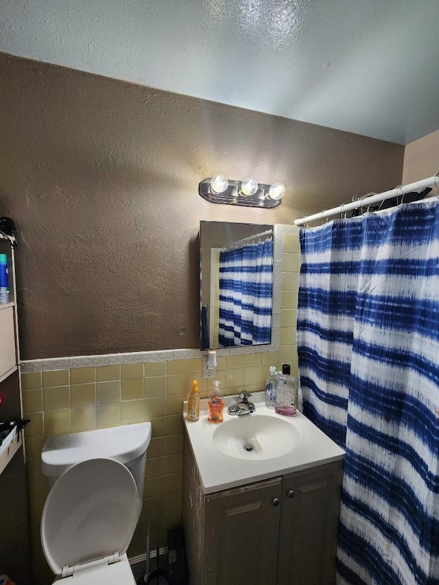 bathroom featuring tile walls, vanity, toilet, and walk in shower