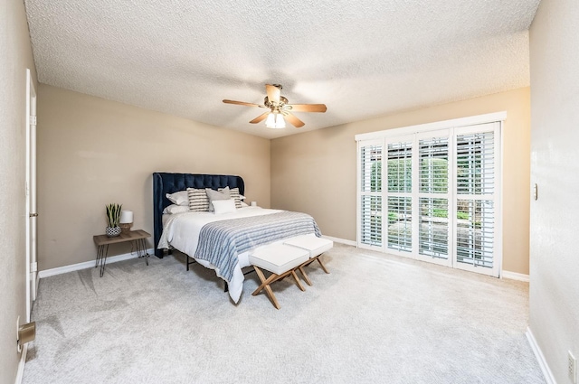 carpeted bedroom with ceiling fan and a textured ceiling