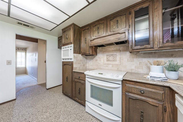 kitchen featuring light carpet, white appliances, premium range hood, and backsplash