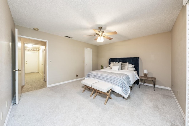 bedroom with ceiling fan, carpet floors, and a textured ceiling