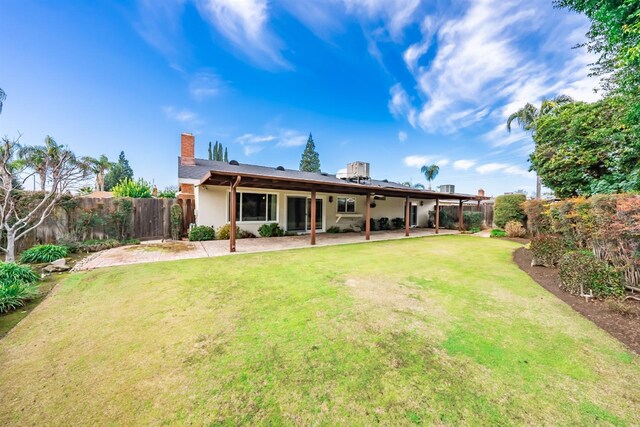 back of property featuring a patio and a lawn