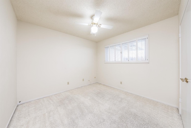 carpeted spare room featuring a textured ceiling and ceiling fan