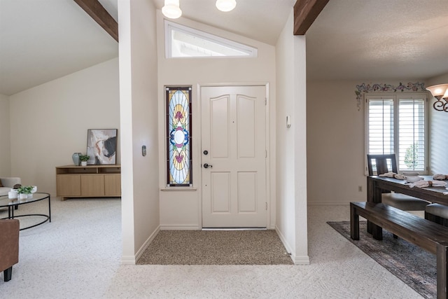 carpeted entryway with vaulted ceiling with beams