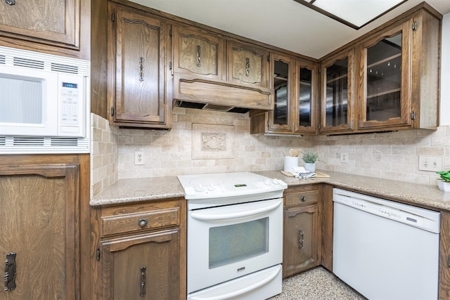 kitchen featuring backsplash and white appliances