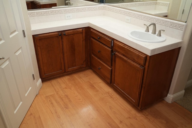 bathroom featuring decorative backsplash, wood-type flooring, and vanity