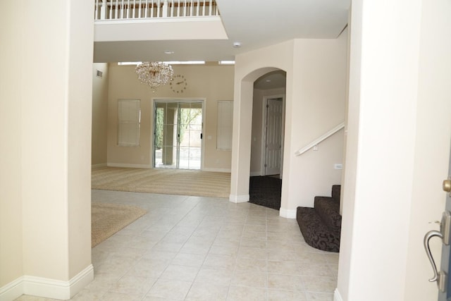 carpeted entryway featuring a chandelier