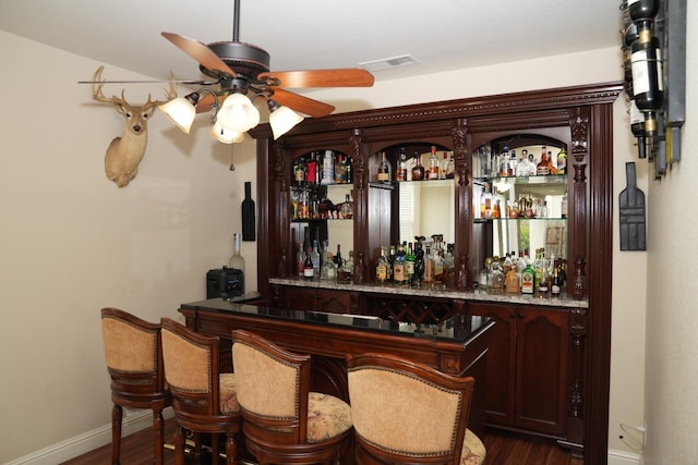 bar featuring dark hardwood / wood-style floors and ceiling fan