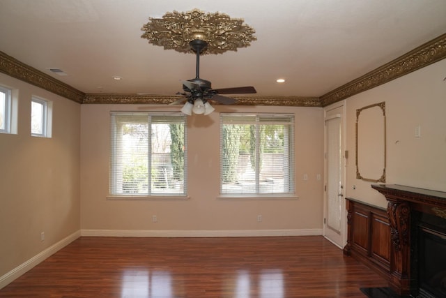 unfurnished living room featuring crown molding, ceiling fan, and dark wood-type flooring