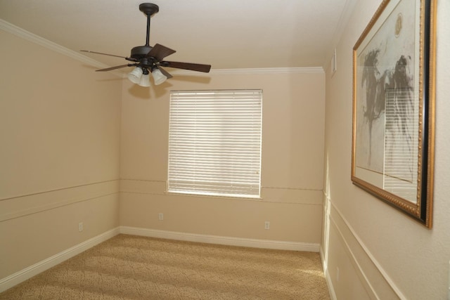 spare room with ceiling fan, crown molding, and light carpet