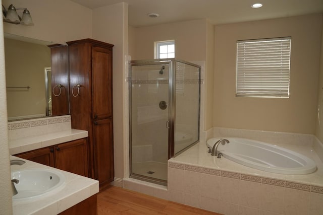 bathroom with separate shower and tub, vanity, and hardwood / wood-style flooring