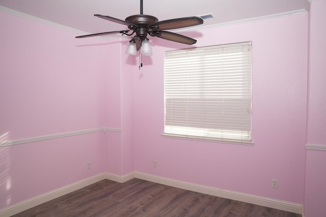 spare room featuring a wealth of natural light, ceiling fan, dark hardwood / wood-style flooring, and ornamental molding