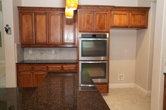 kitchen featuring double oven, dark stone countertops, and decorative backsplash