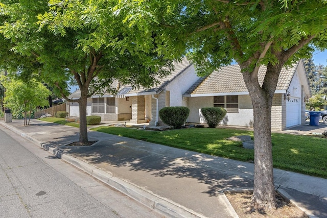 view of front of house featuring a garage and a front lawn