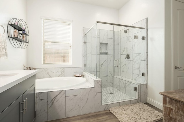 bathroom featuring vanity, wood-type flooring, and shower with separate bathtub