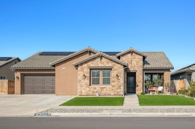 view of front of property with a garage, a front yard, and solar panels