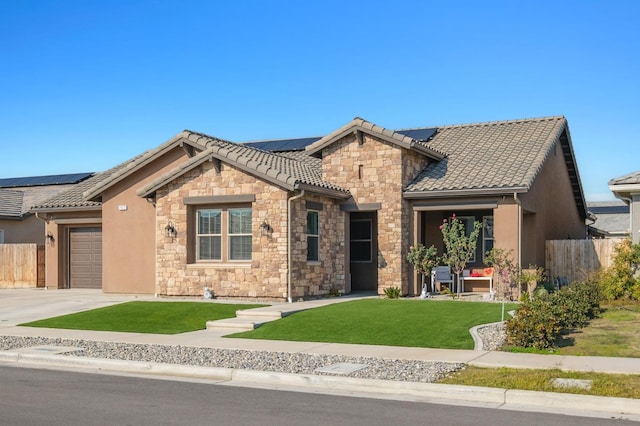 view of front of home featuring solar panels, a garage, and a front yard