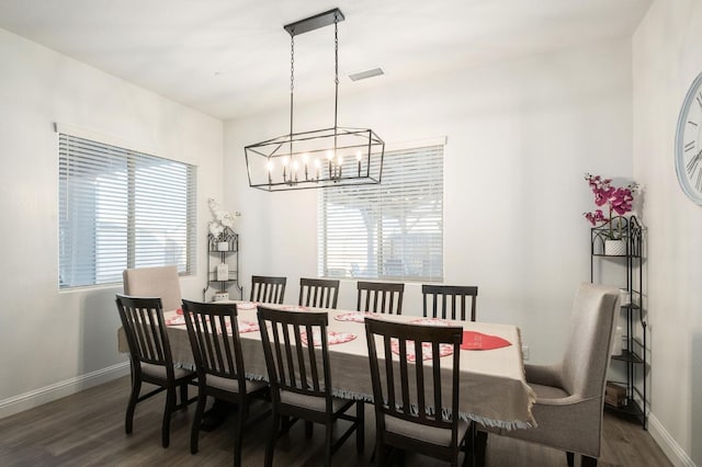 dining area with a chandelier and dark hardwood / wood-style flooring