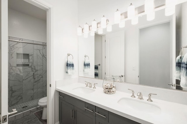 bathroom featuring a shower with door, vanity, and toilet