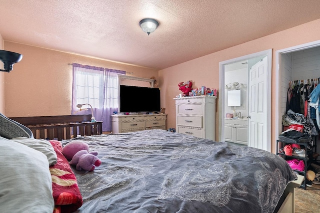 bedroom with a textured ceiling and connected bathroom