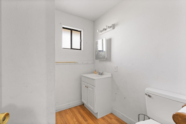 bathroom with hardwood / wood-style floors, vanity, and toilet