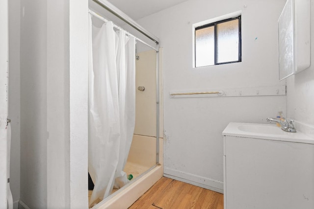 bathroom with hardwood / wood-style flooring, a shower with curtain, and sink