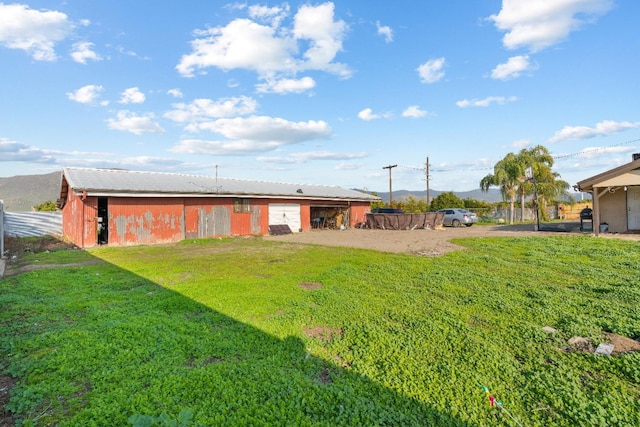 back of property featuring an outdoor structure and a lawn