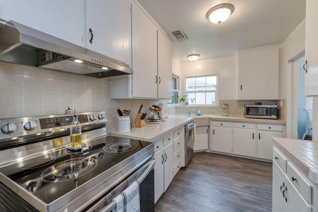 kitchen with backsplash, dark hardwood / wood-style flooring, stainless steel appliances, and white cabinetry