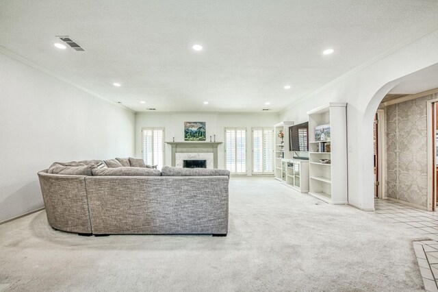 living room featuring a textured ceiling, a wealth of natural light, crown molding, and light carpet